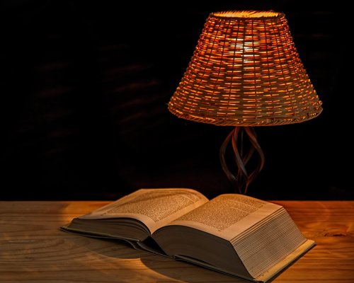 Cozy reading corner with warm lamp light and books