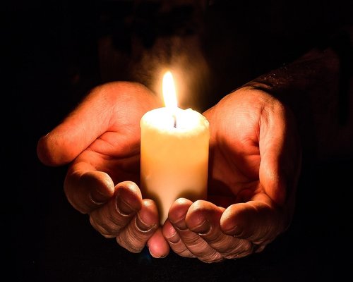 Hands holding an open book under soft lighting