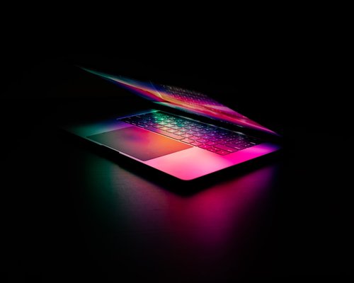 A dark room with only a laptop screen glowing