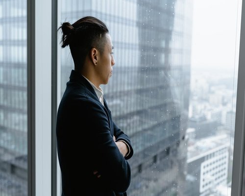 A person looking out of an office window taking a break