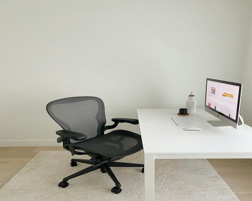 Organized modern workspace with a monitor and ergonomic chair