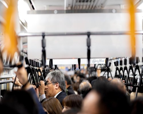 Commuter listening to music with headphones on public transport